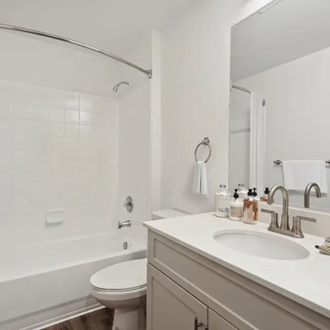 A white bathroom with a toilet, sink, and shower.